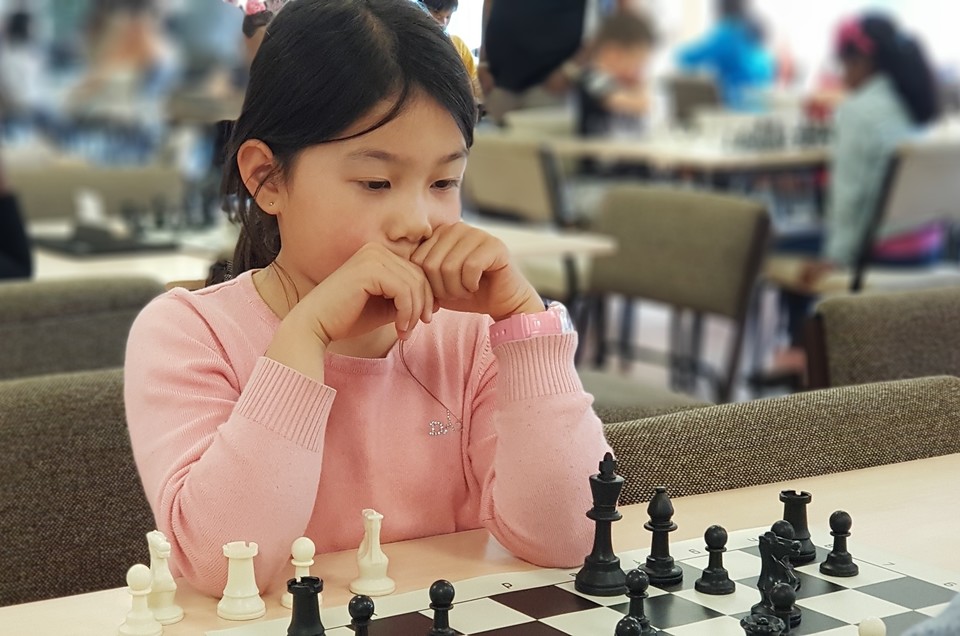 Young girl enjoying chess